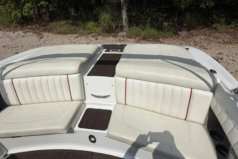 Slide: The Image of 2007 Cobalt 250 boat interior with white cushioned seating and wood accents. - 19