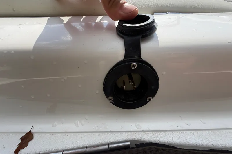 Slide: The Image of Boat fuel cap on a 2007 Cobalt 250, with water droplets and a leaf nearby. - 23