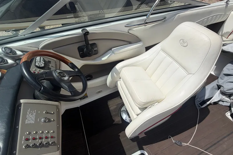Slide: The Image of Interior of a 2007 Cobalt 250 boat featuring a steering wheel and white captain's chair. - 13