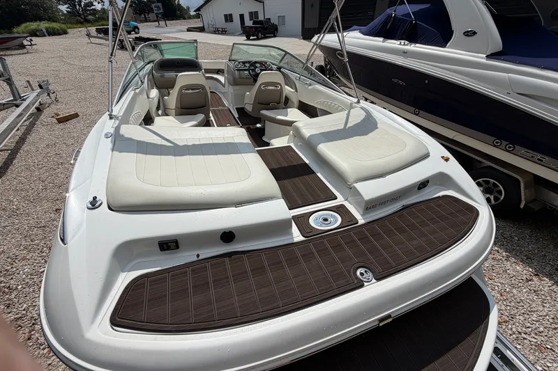 Slide: The Image of 2007 Cobalt 250 boat with white seating and wood accents, parked outdoors. - 22