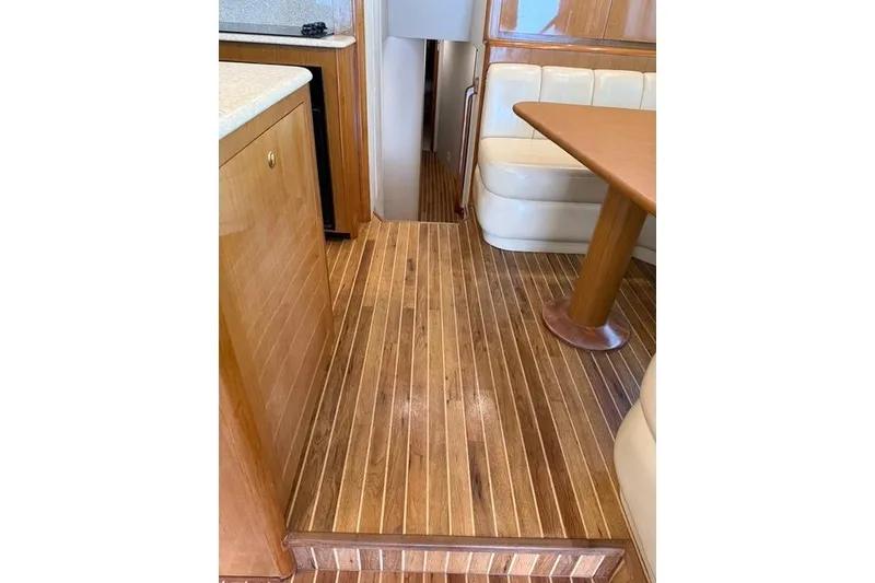 Slide: The Image of Interior of 2003 Viking 65 EB yacht with wooden flooring and seating area. - 27