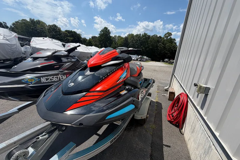 Slide: The Image of 2022 Yamaha WaveRunner VX Cruiser HO in vibrant red and black, parked outdoors. - 2