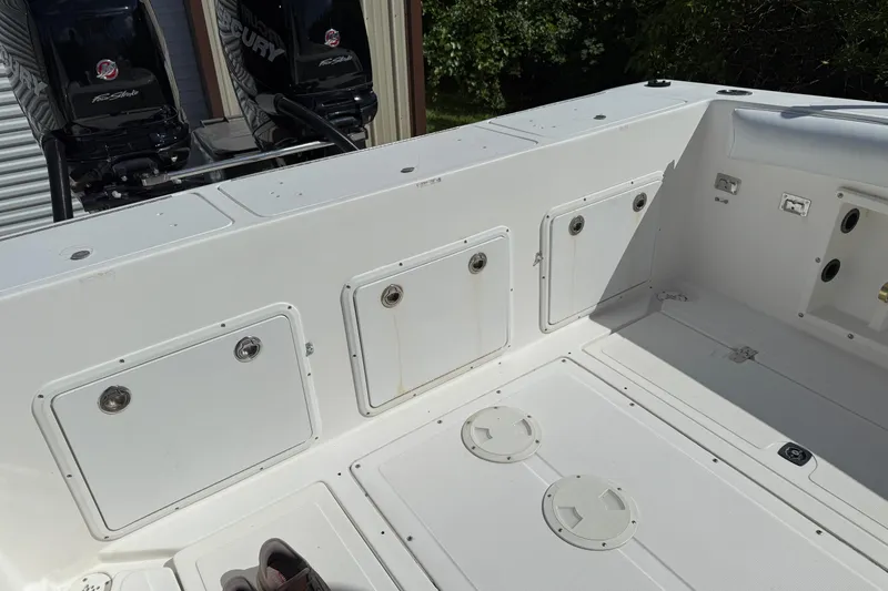 Slide: The Image of 2001 Marlago 35 Cuddy boat deck with storage compartments and twin Mercury engines. - 10