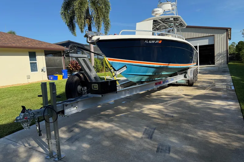 Slide: The Image of 2001 Marlago 35 Cuddy boat on trailer, parked in driveway near garage. - 2