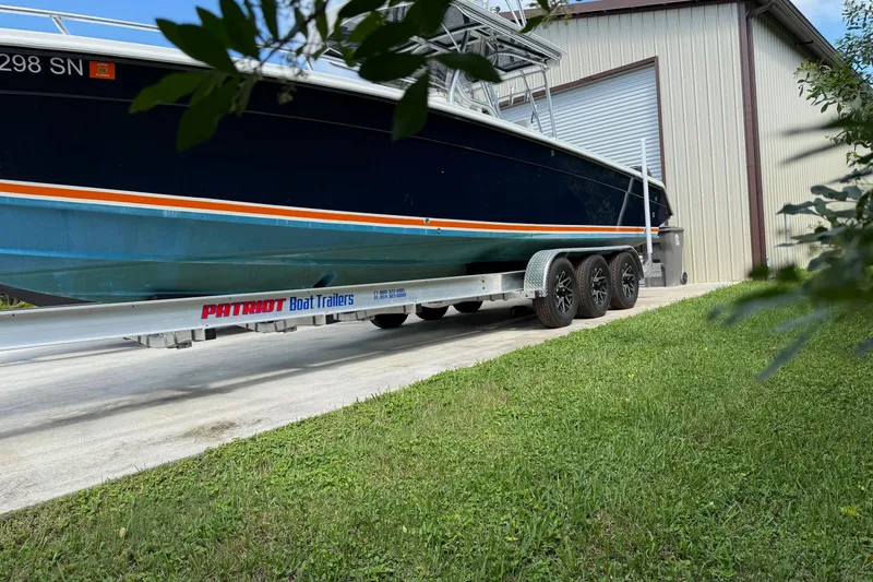 Slide: The Image of 2001 Marlago 35 Cuddy boat on Patriot trailer near a storage building. - 17