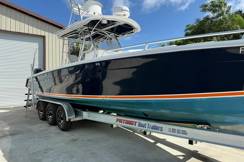 Slide: The Image of 2001 Marlago 35 Cuddy boat on trailer, parked outside a storage facility. - 1