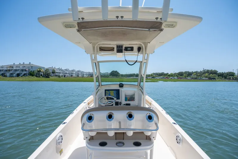 Slide: The Image of 2019 Scout 251 XSS boat on calm water with scenic shoreline view. - 12
