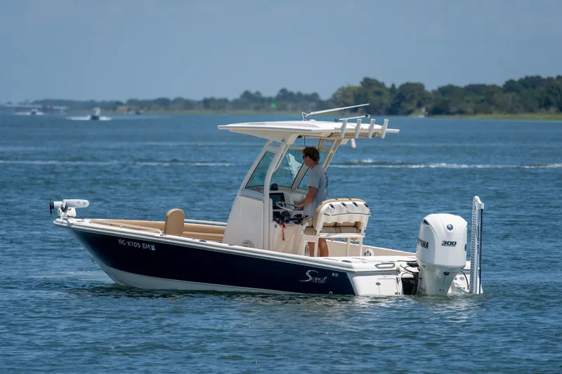 Slide: The Image of 2019 Scout 251 XSS boat cruising on a calm lake with a Yamaha engine. - 6