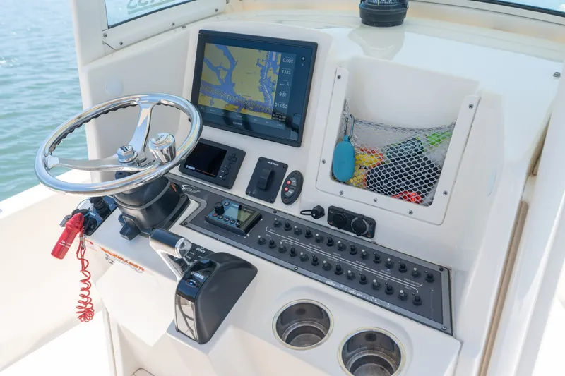 Slide: The Image of 2019 Scout 251 XSS boat dashboard with navigation screen and steering wheel. - 14