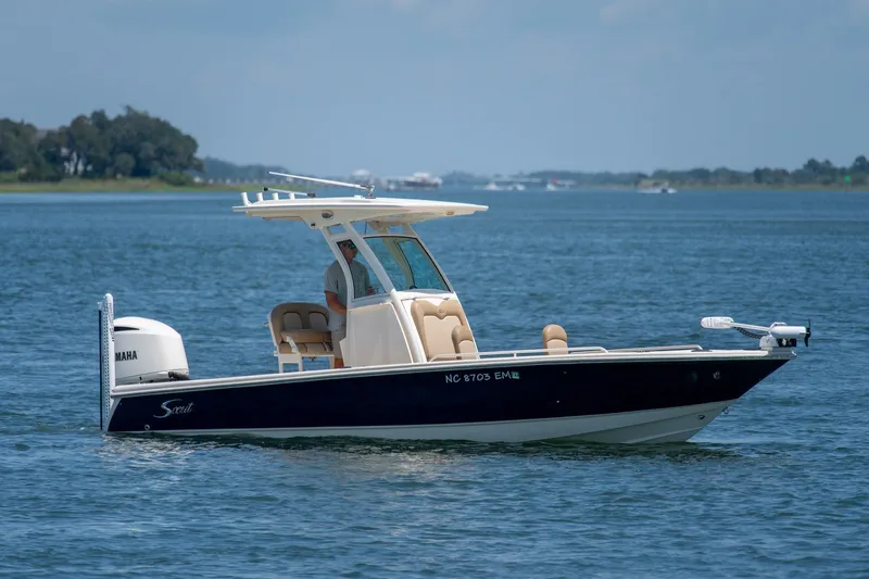 Slide: The Image of 2019 Scout 251 XSS boat cruising on a calm blue lake with scenic background. - 2