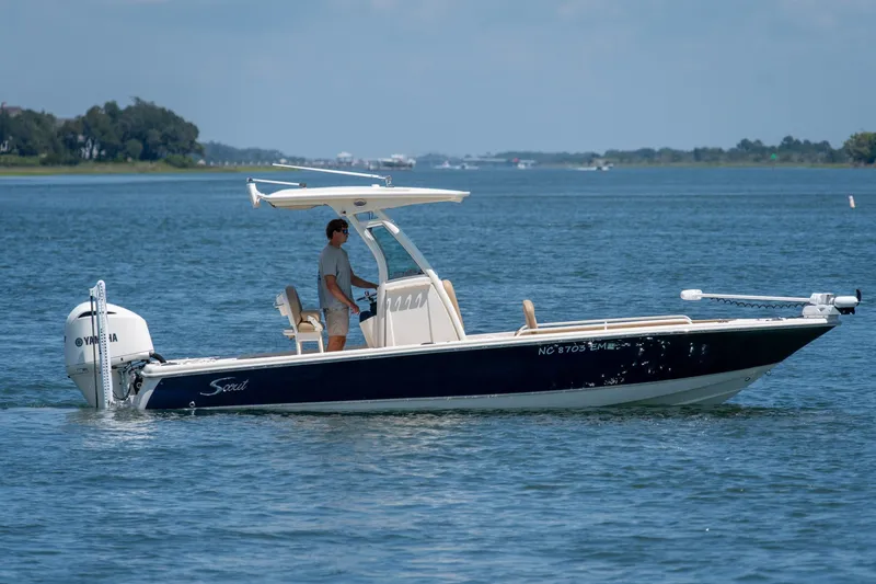 Slide: The Image of 2019 Scout 251 XSS boat cruising on a calm lake with a Yamaha engine. - 1