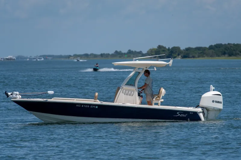 Slide: The Image of 2019 Scout 251 XSS boat cruising on a calm lake with a Yamaha engine. - 5