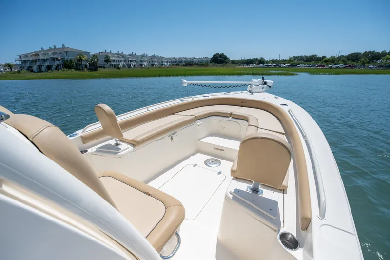 Slide: The Image of 2019 Scout 251 XSS boat interior with beige seating on calm water. - 16