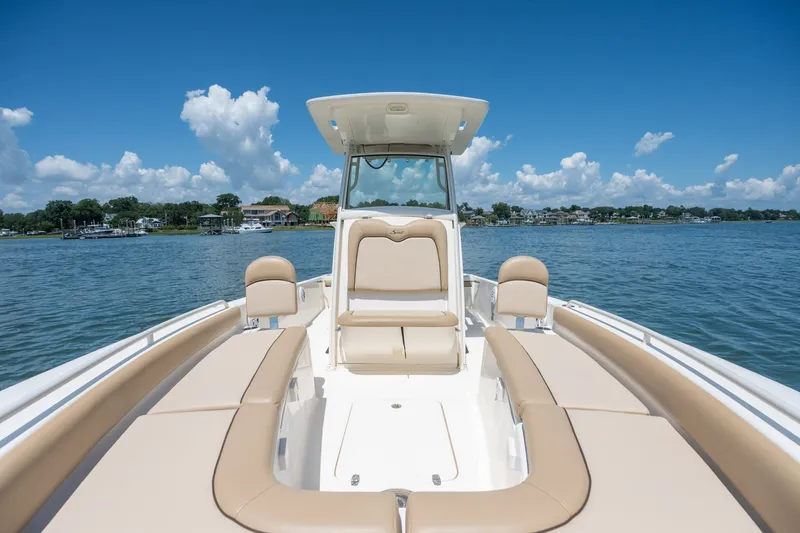 Slide: The Image of 2019 Scout 251 XSS boat on calm water, featuring spacious seating and clear skies. - 18