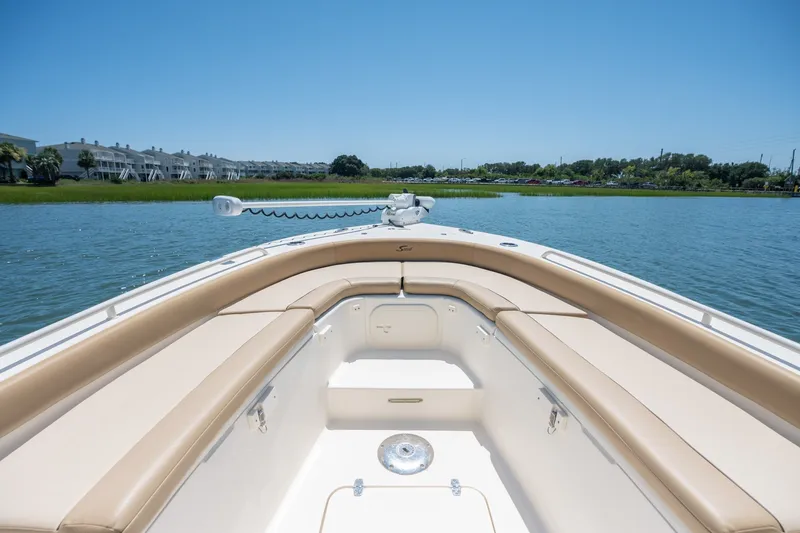 Slide: The Image of 2019 Scout 251 XSS boat interior with tan seating on a sunny day. - 17