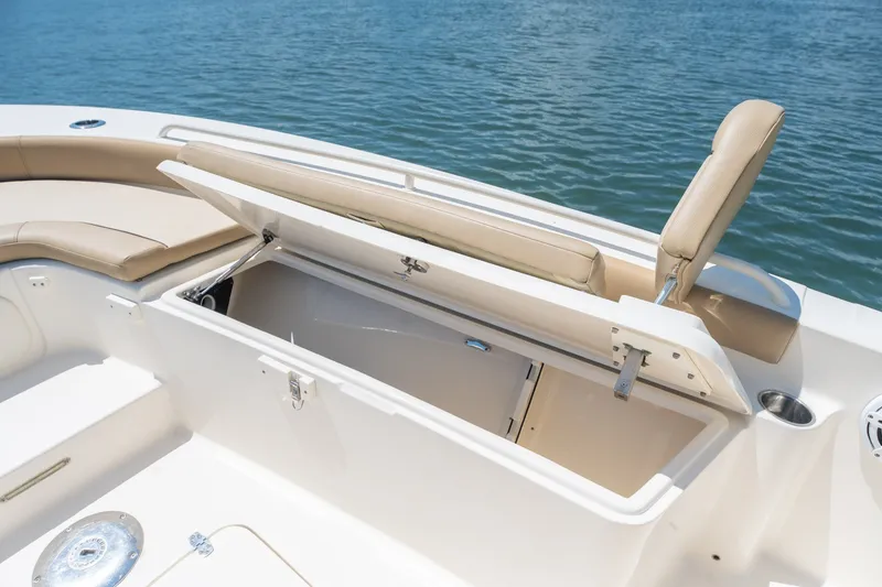 Slide: The Image of 2019 Scout 251 XSS boat with open storage compartment and beige seating. - 25