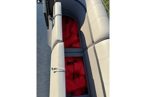 Slide: The Image of 2023 Angler Qwest 22' Pro Family Fish boat seating with red life jackets stored underneath. - 20