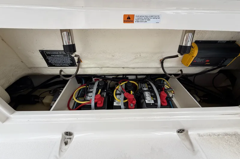 Slide: The Image of 2019 Robalo R272 Center Console boat battery compartment with wiring and warning labels. - 25