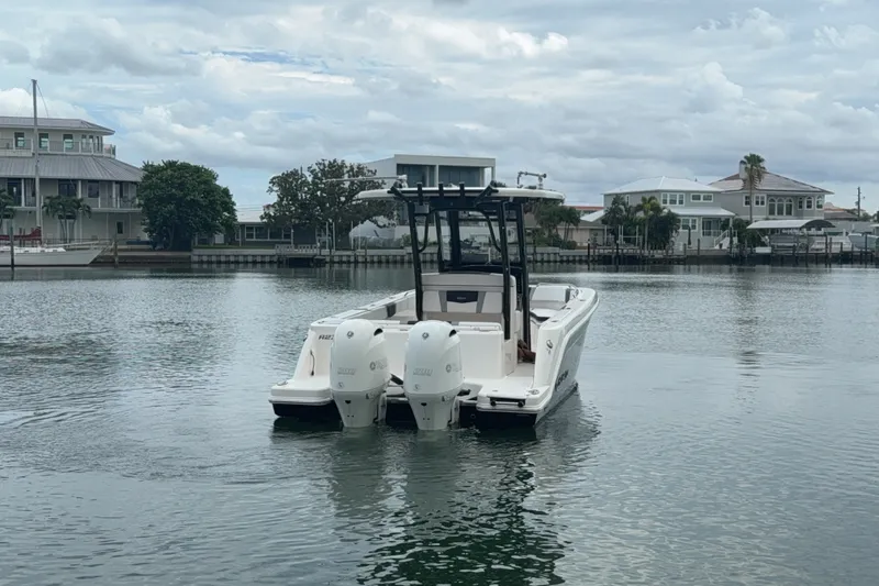 Slide: The Image of 2019 Robalo R272 Center Console boat on calm water near waterfront homes. - 31