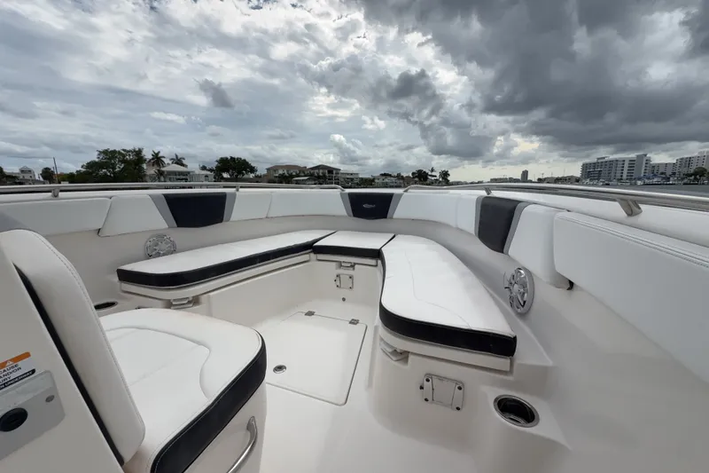 Slide: The Image of 2019 Robalo R272 Center Console boat interior with cushioned seating under cloudy skies. - 15