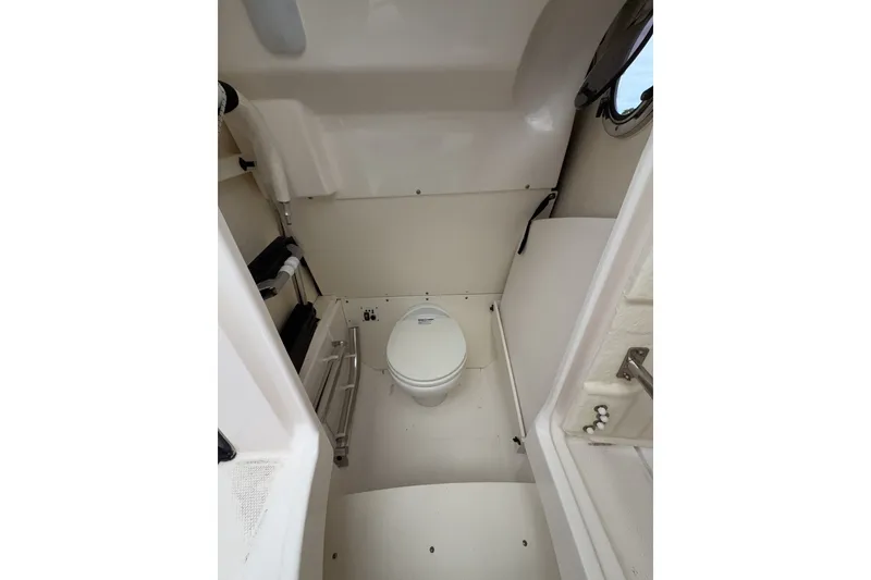 Slide: The Image of 2019 Robalo R272 Center Console boat interior with compact marine toilet. - 27