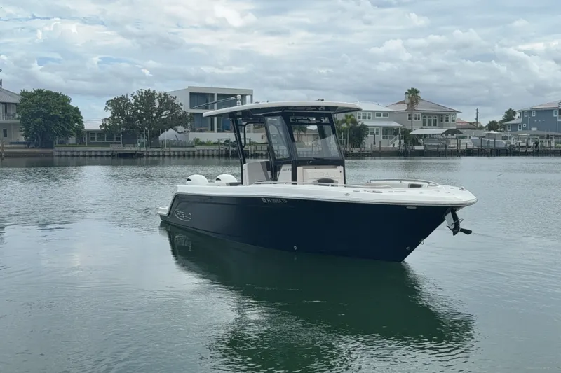 Slide: The Image of 2019 Robalo R272 Center Console boat on calm water near waterfront homes. - 29