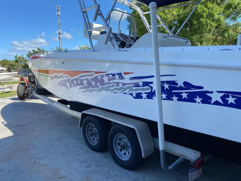 Slide: The Image of 1999 Wellcraft 302 Sport boat on a trailer with star-spangled graphics. - 4