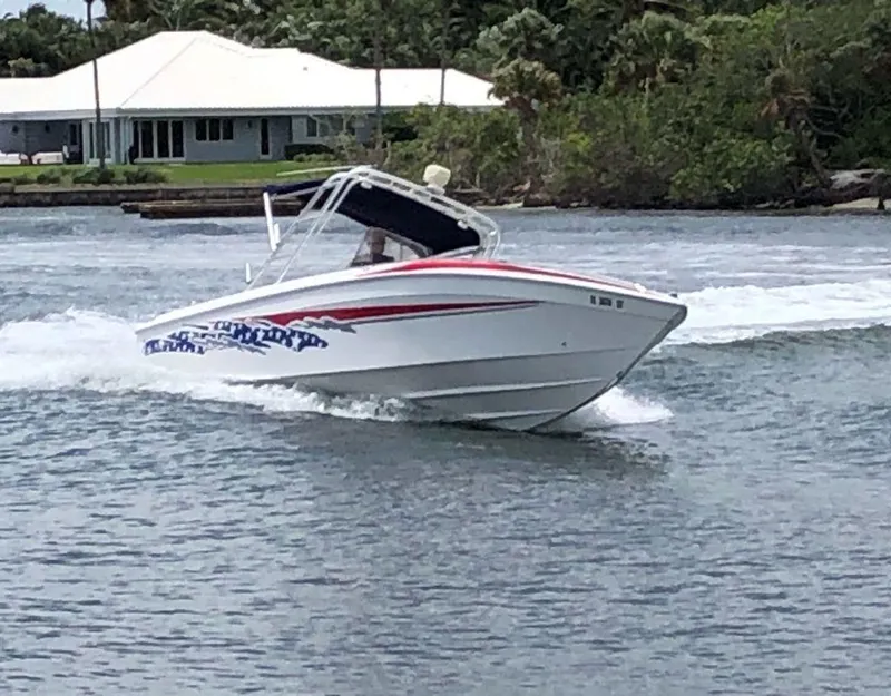 Slide: The Image of 1999 Wellcraft 302 Sport boat cruising on a lake with a house in the background. - 3