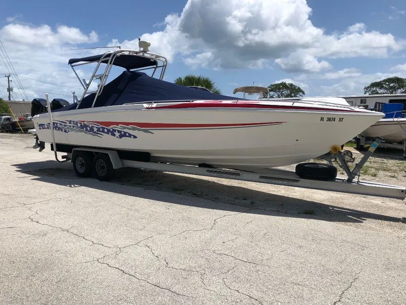 Slide: The Image of 1999 Wellcraft 302 Sport boat on a trailer under a cloudy sky. - 2