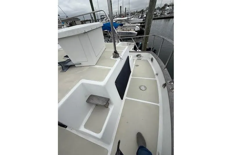 Slide: The Image of 1987 Monk 36 Trawler deck view at marina, showcasing spacious layout and railing. - 3