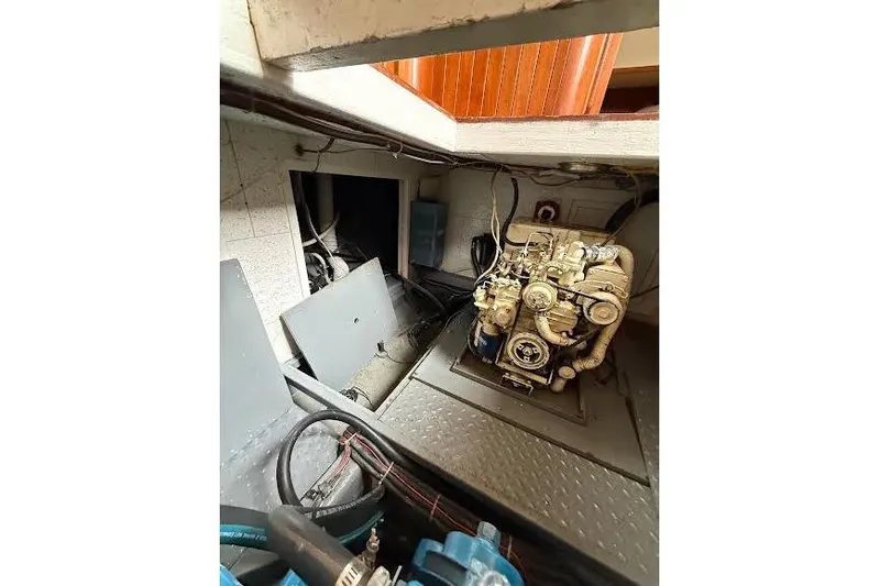 Slide: The Image of Engine room of a 1987 Monk 36 Trawler, showcasing mechanical components and wiring. - 26
