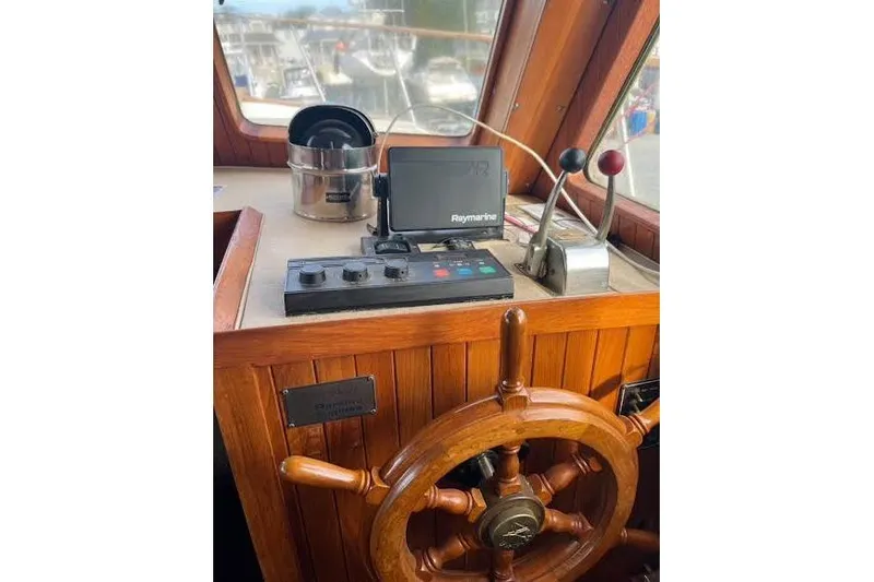 Slide: The Image of 1987 Monk 36 Trawler helm with wooden wheel and Raymarine navigation system. - 11