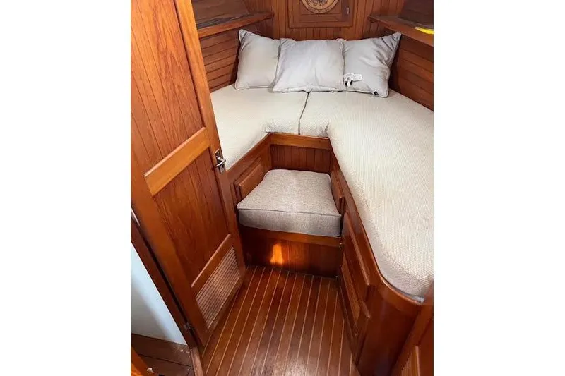 Slide: The Image of 1987 Monk 36 Trawler cabin interior with wooden finish and cozy bedding. - 21