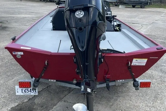 Slide: The Image of 2020 Crestliner 1700 Storm boat, red exterior, rear view with motor, parked on concrete. - 3