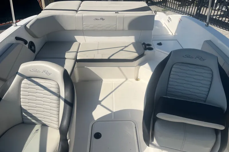 Slide: The Image of 2023 Sea Ray SPX 210 Outboard boat interior with cushioned seating and steering area. - 3