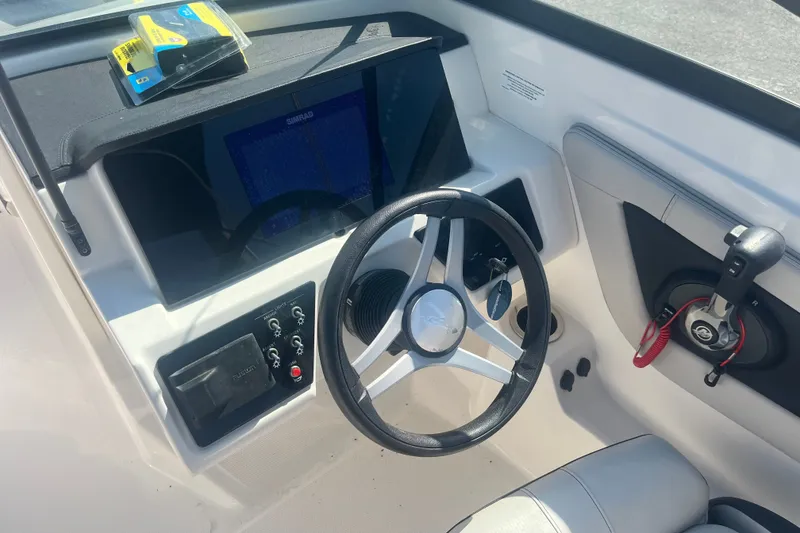 Slide: The Image of 2023 Sea Ray SPX 210 Outboard dashboard with steering wheel and controls. - 6
