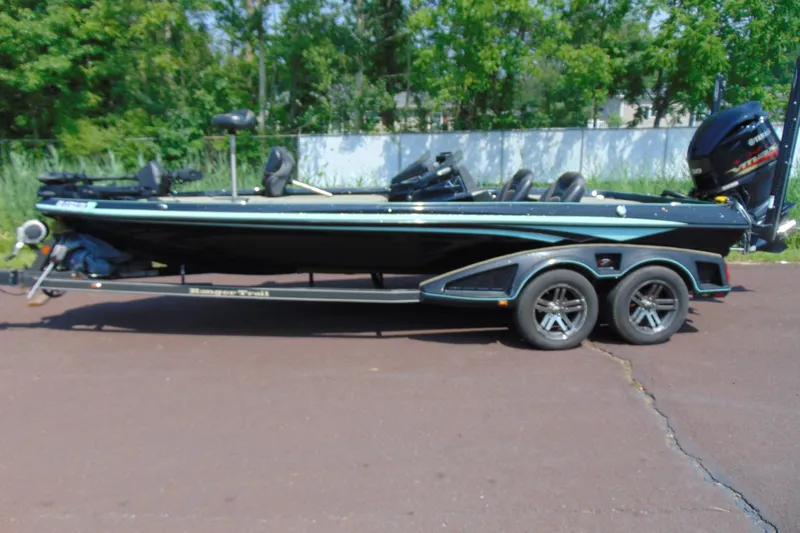 Slide: The Image of 2016 Ranger Z521L boat on trailer, parked outdoors with green foliage background. - 2