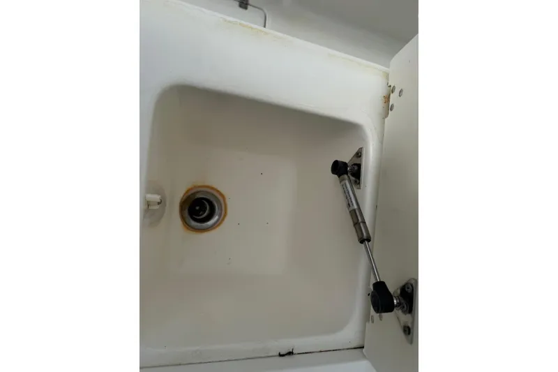 Slide: The Image of Interior compartment of 2013 Sea Fox 286 Center Console boat, featuring a gas strut and drain. - 21