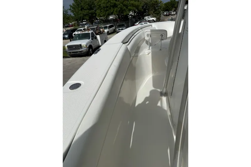 Slide: The Image of 2013 Sea Fox 286 Center Console boat deck with white interior and parked vehicles nearby. - 28