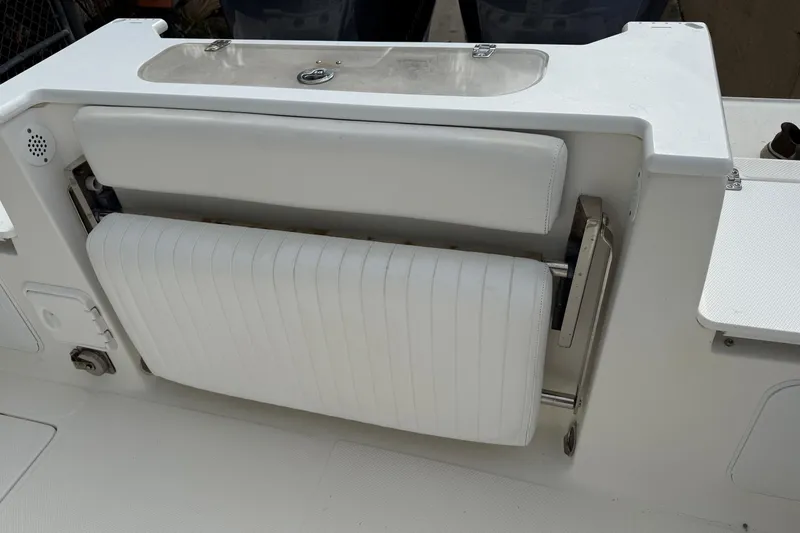 Slide: The Image of 2013 Sea Fox 286 Center Console boat with white cushioned seating and storage compartment. - 17