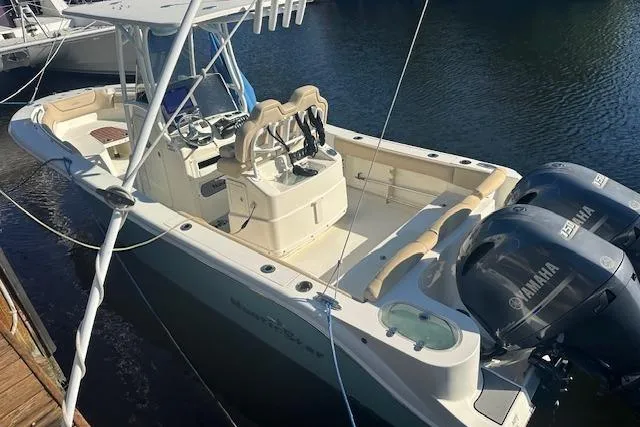 Slide: The Image of 2018 NauticStar 2602 Legacy boat with dual Yamaha engines docked on calm water. - 8