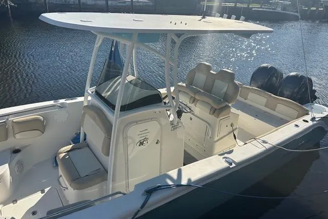 Slide: The Image of 2018 NauticStar 2602 Legacy boat with dual engines, docked on calm water. - 1