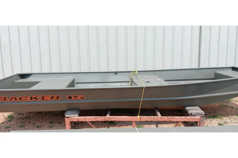 The Image of 2027 Tracker Grizzly 15 Jon boat displayed outdoors on a stand. - 0