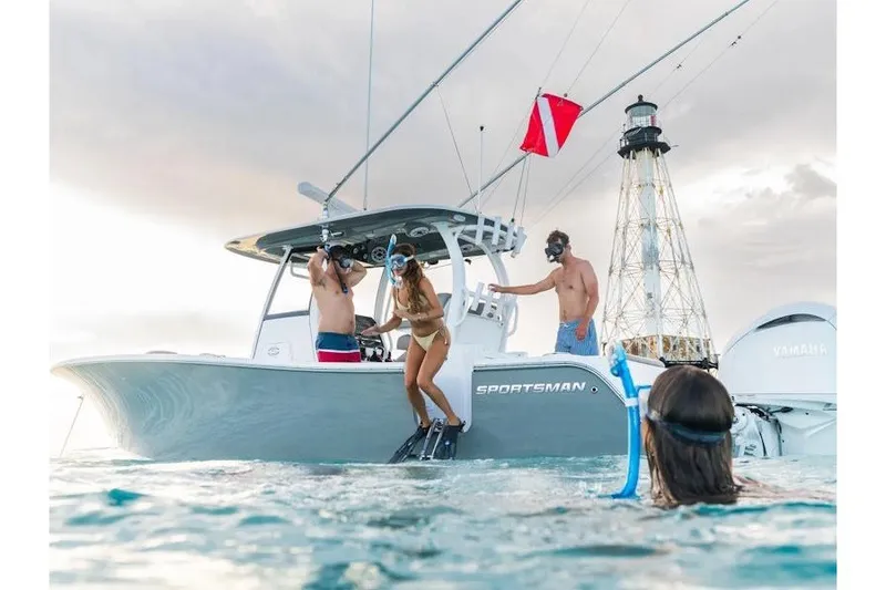 The Image of People snorkeling near a 2027 Sportsman Open 282 Center Console boat by a lighthouse. - 1