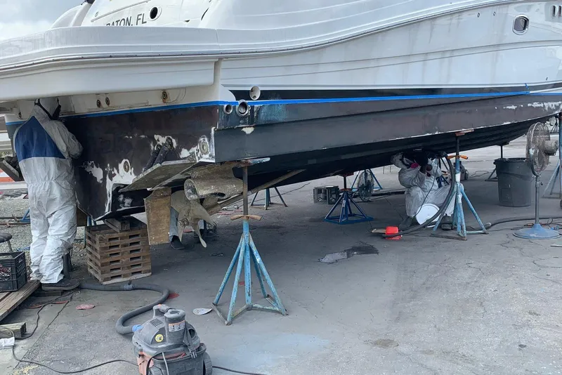 Slide: The Image of Workers refurbishing a 2007 Sea Ray 48 Sundancer yacht hull in a boatyard. - 20