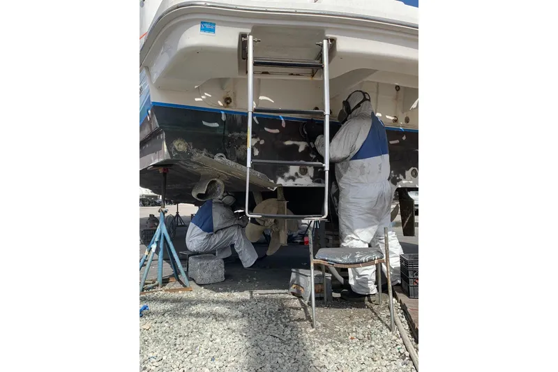 Slide: The Image of Workers in protective gear repairing a 2007 Sea Ray 48 Sundancer yacht hull. - 21