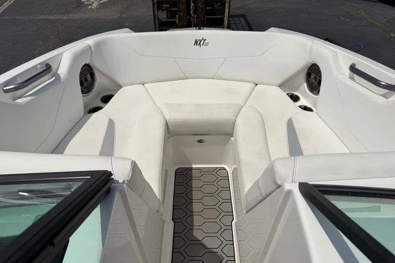 Slide: The Image of 2022 MasterCraft NXT20 boat interior with white seating and hexagonal floor design. - 10