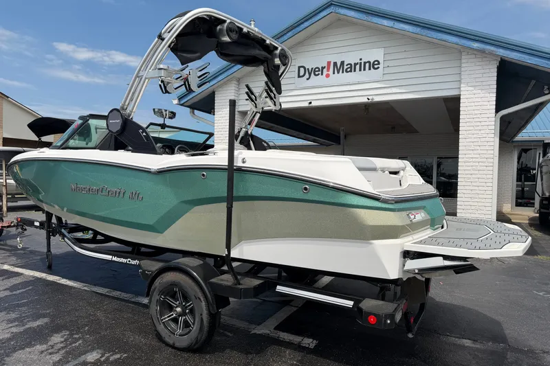Slide: The Image of 2022 MasterCraft NXT20 boat at Dyer Marine dealership, showcasing sleek design and trailer. - 2