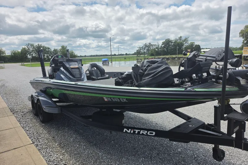 The Image of 2023 Nitro Z21 XL boat on trailer, parked outdoors under cloudy sky. - 0