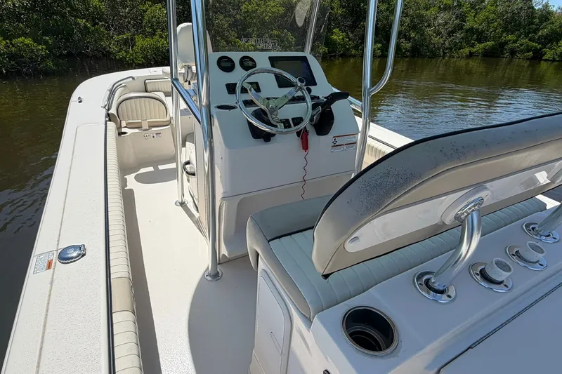 Slide: The Image of 2022 Carolina Skiff 26 Ultra Elite boat interior with steering console on calm water. - 16